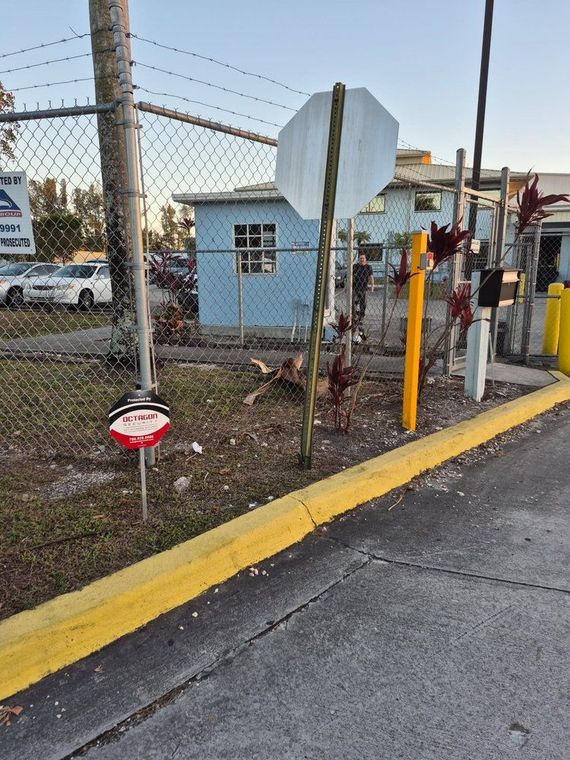 A stop sign is sitting on the side of the road next to a yellow curb