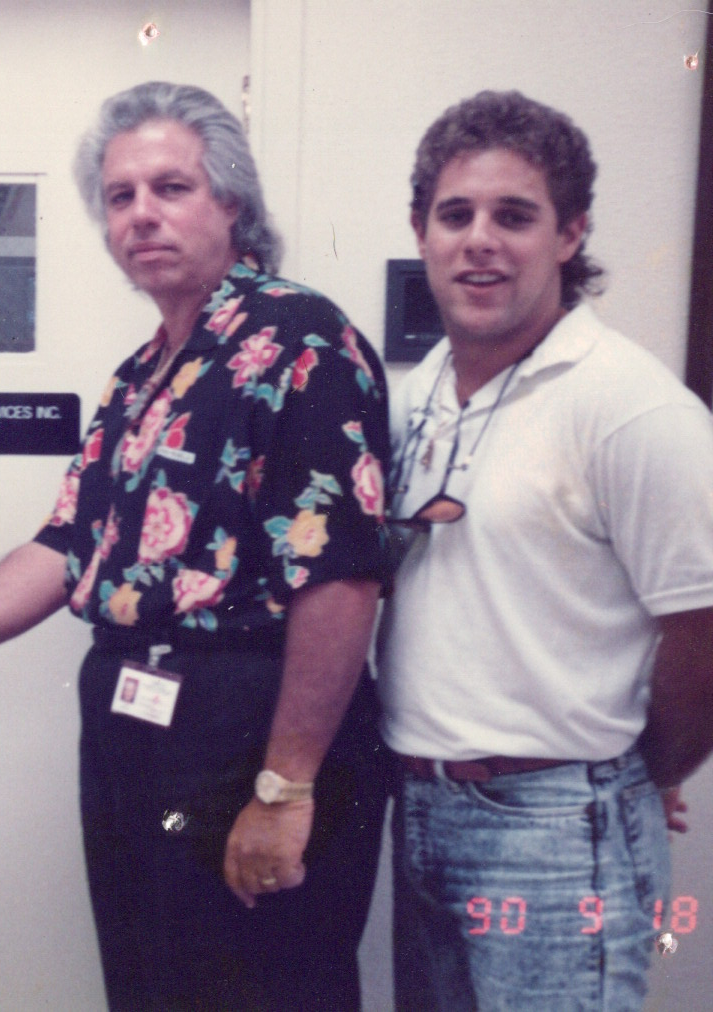 Two men standing next to each other in front of a door that says access nc
