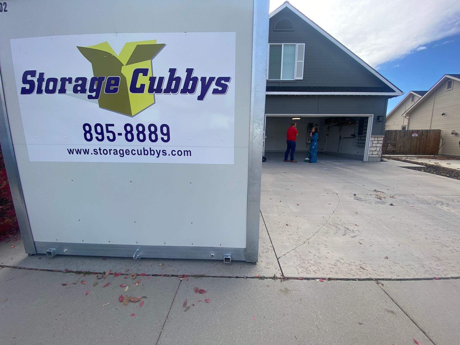 A sign for storage cubby 's is in front of a house