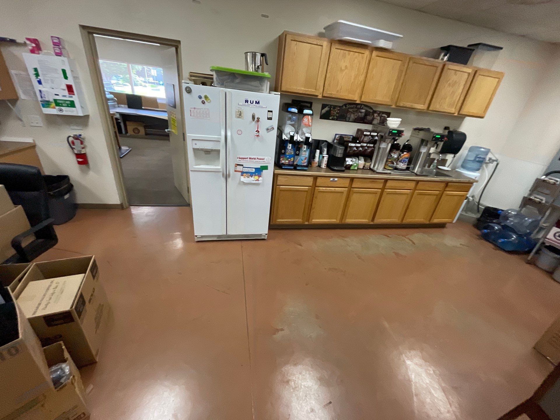 A kitchen with wooden cabinets , a refrigerator , and a coffee maker.