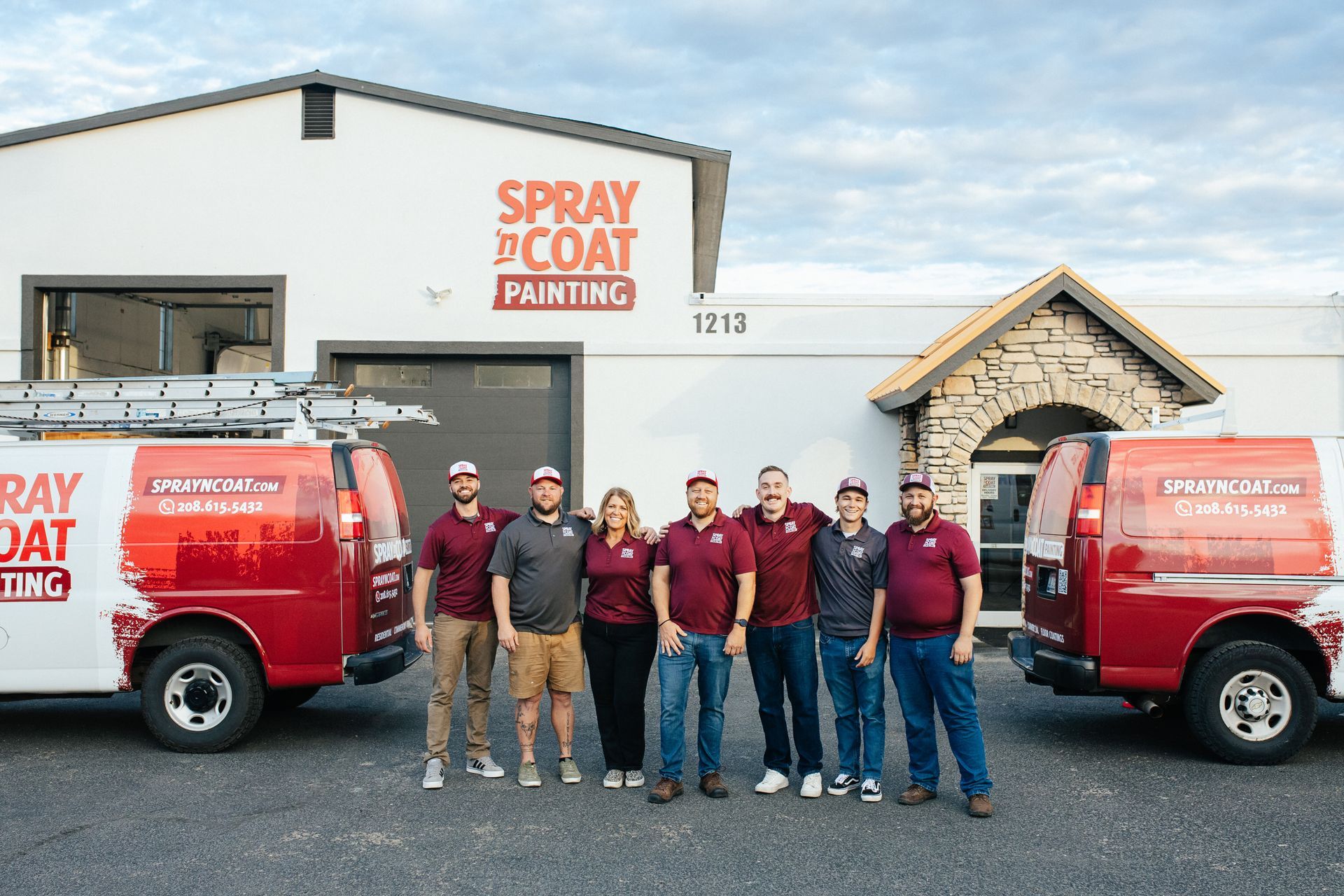 A group of people are posing for a picture in front of a van.