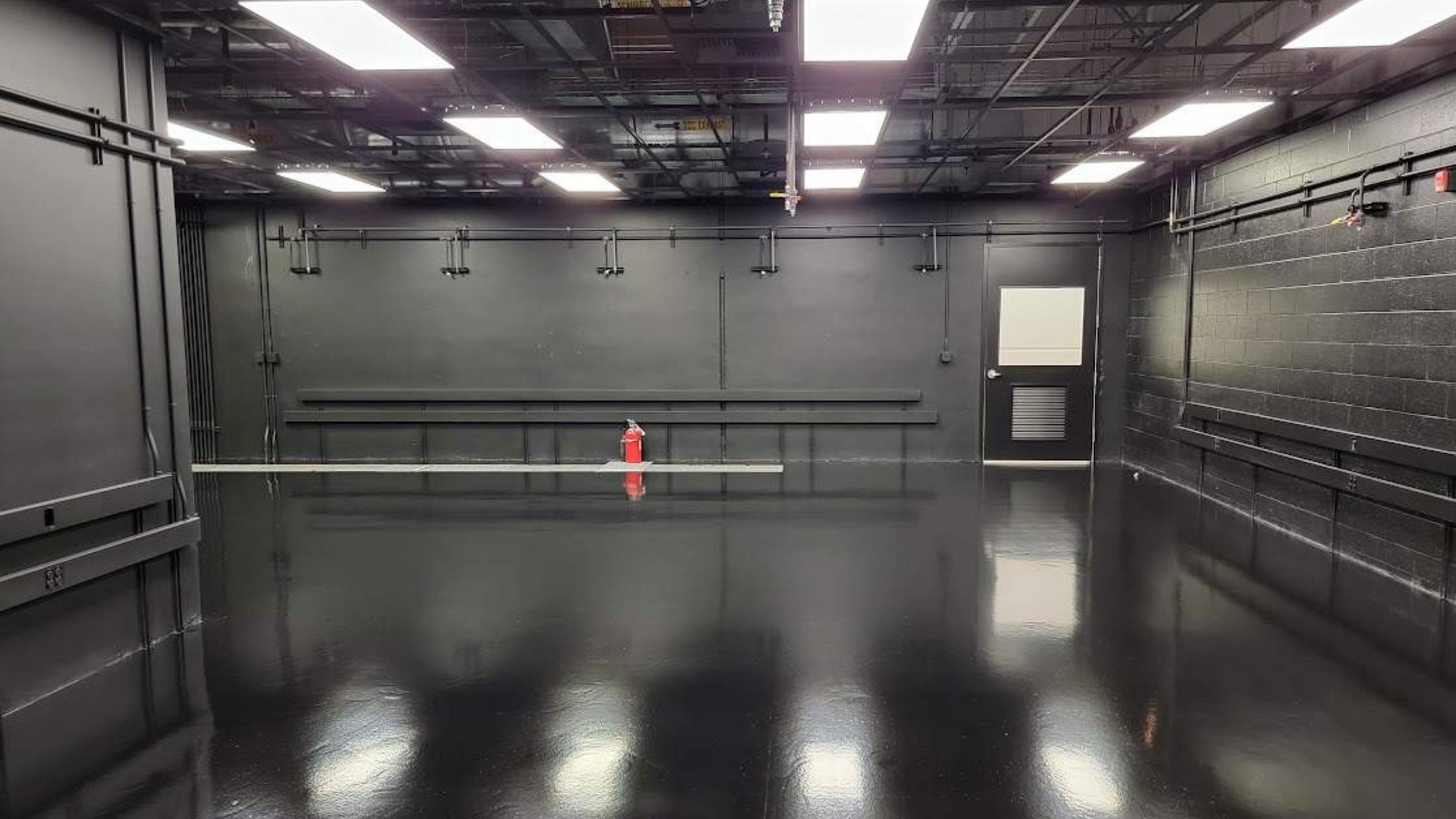 a commercial manufacturing room with fresh painted black walls and a solid black epoxy floor coating