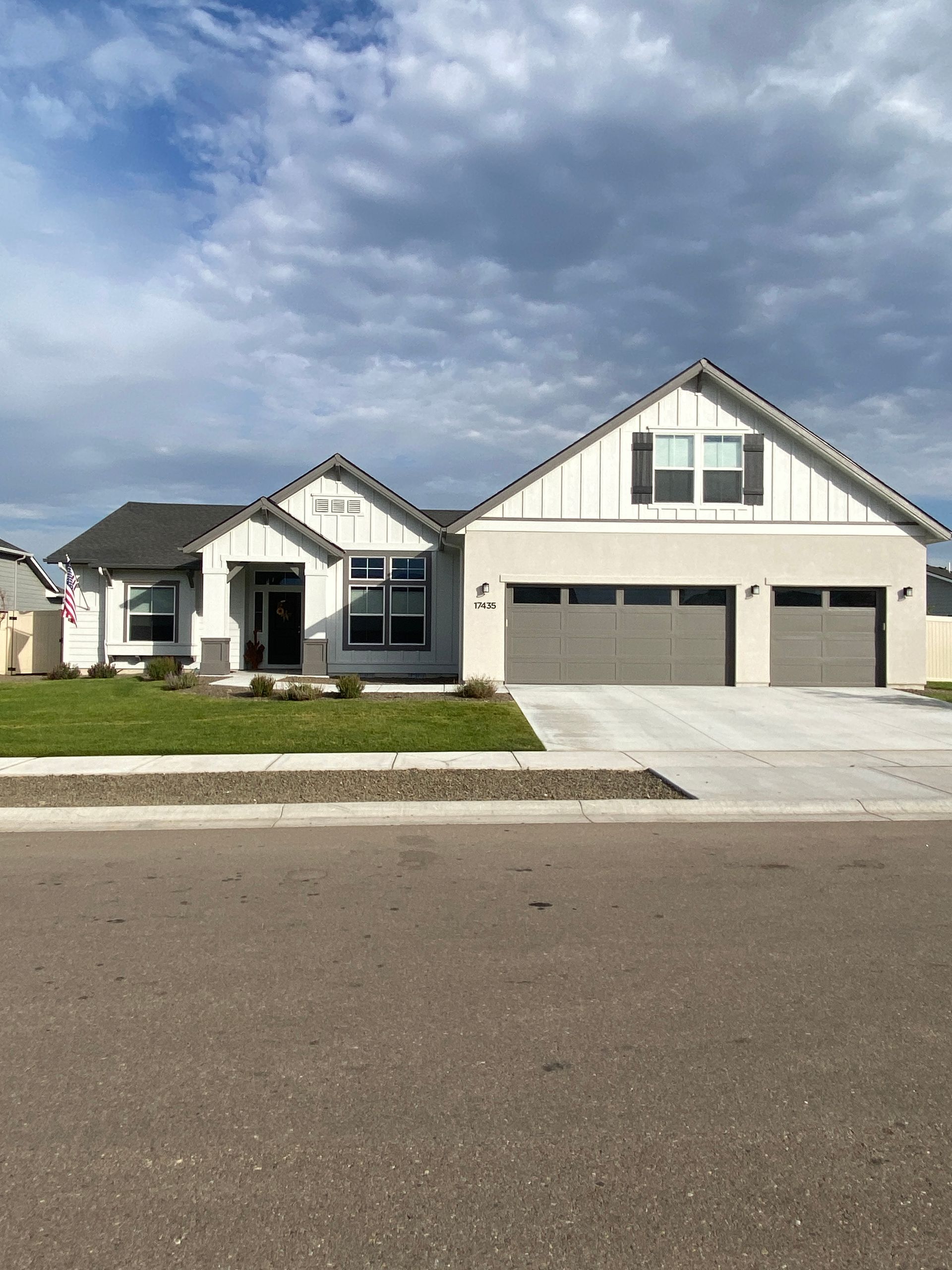 A large white house with a gray garage door