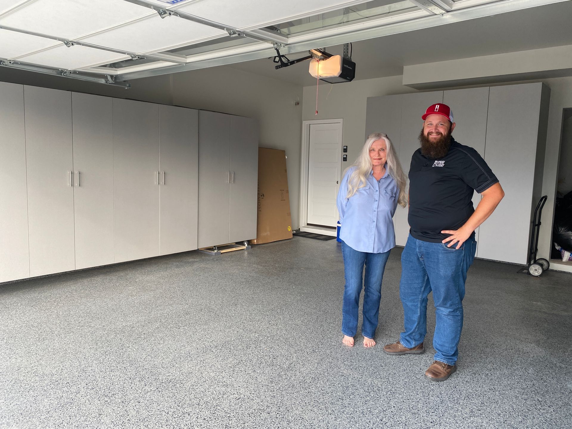 A man and a woman are standing in a garage.