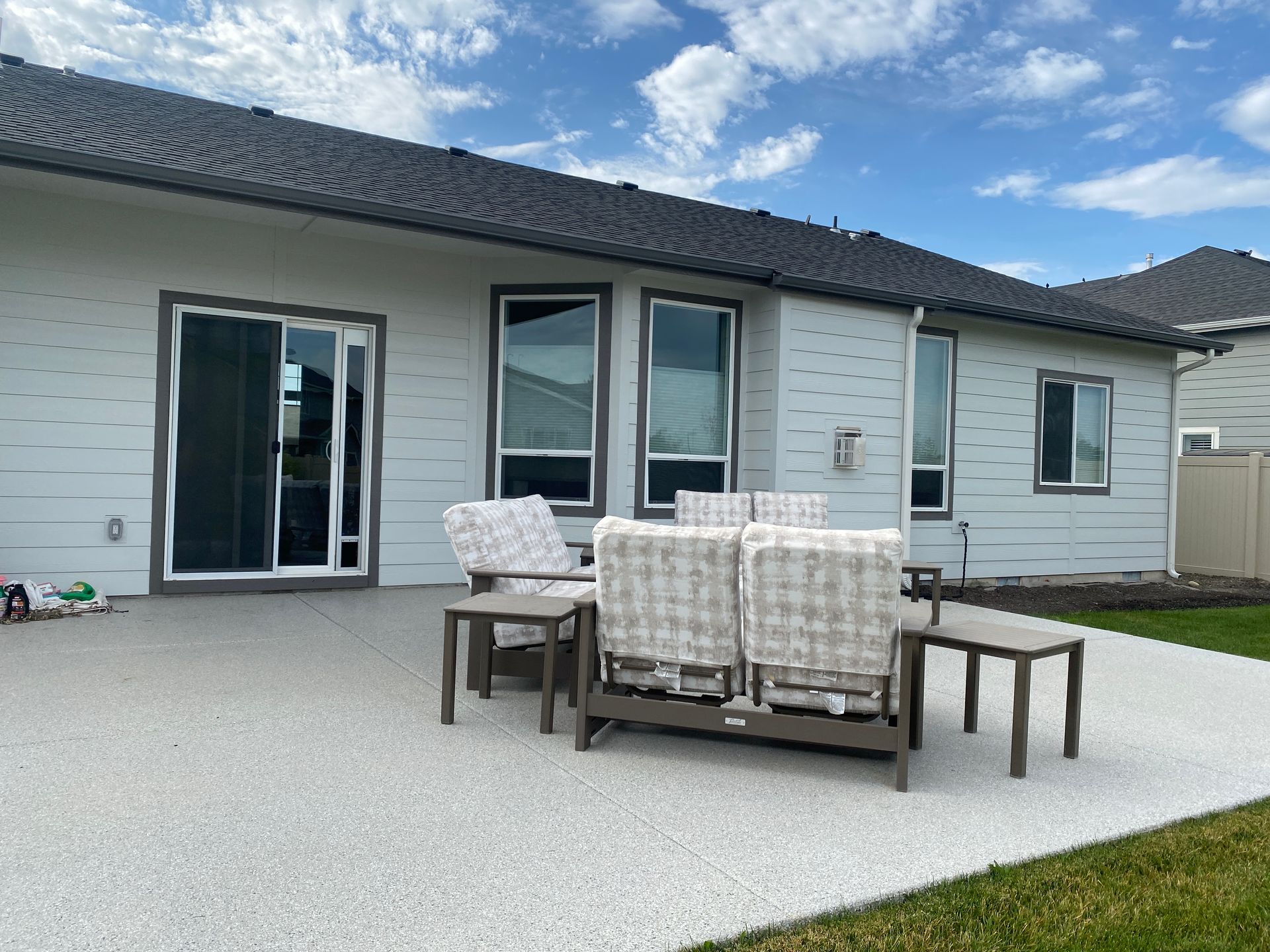 A patio with a table and chairs in front of a house.