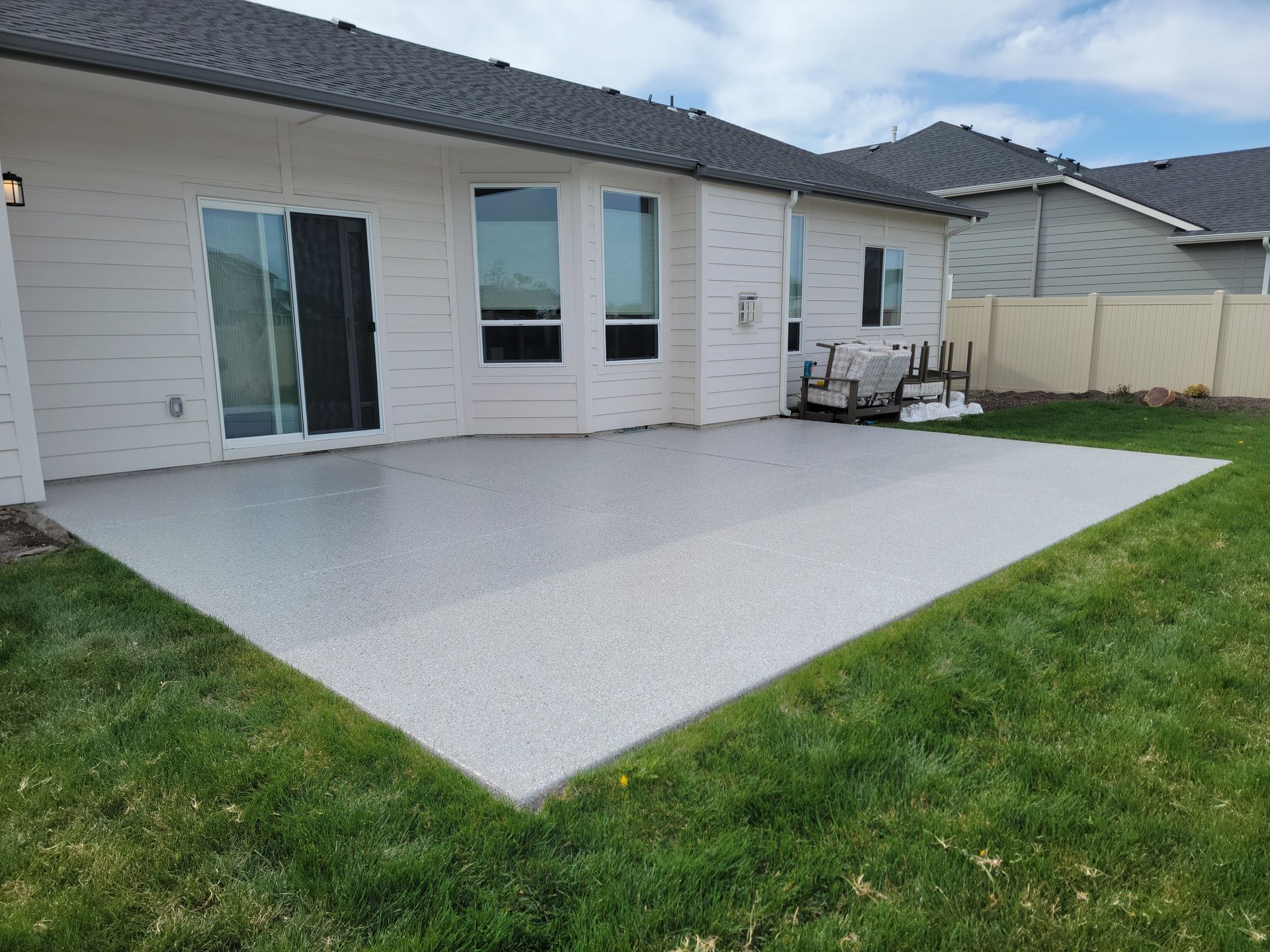 There is a large patio in the backyard of a house.