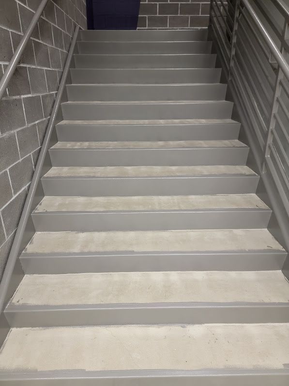 A set of stairs leading up to a brick wall.