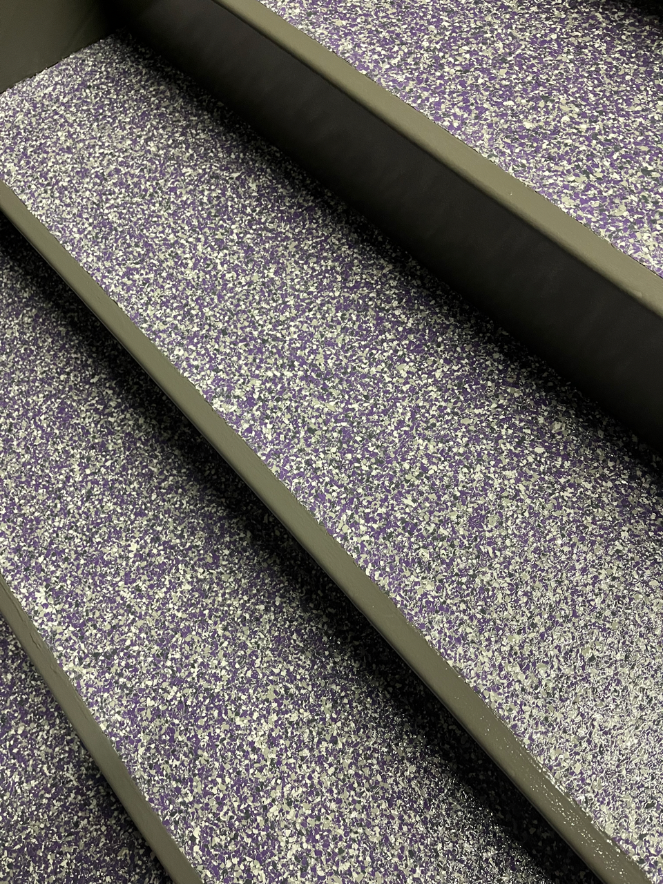 A close up of a set of stairs with a purple and white carpet.