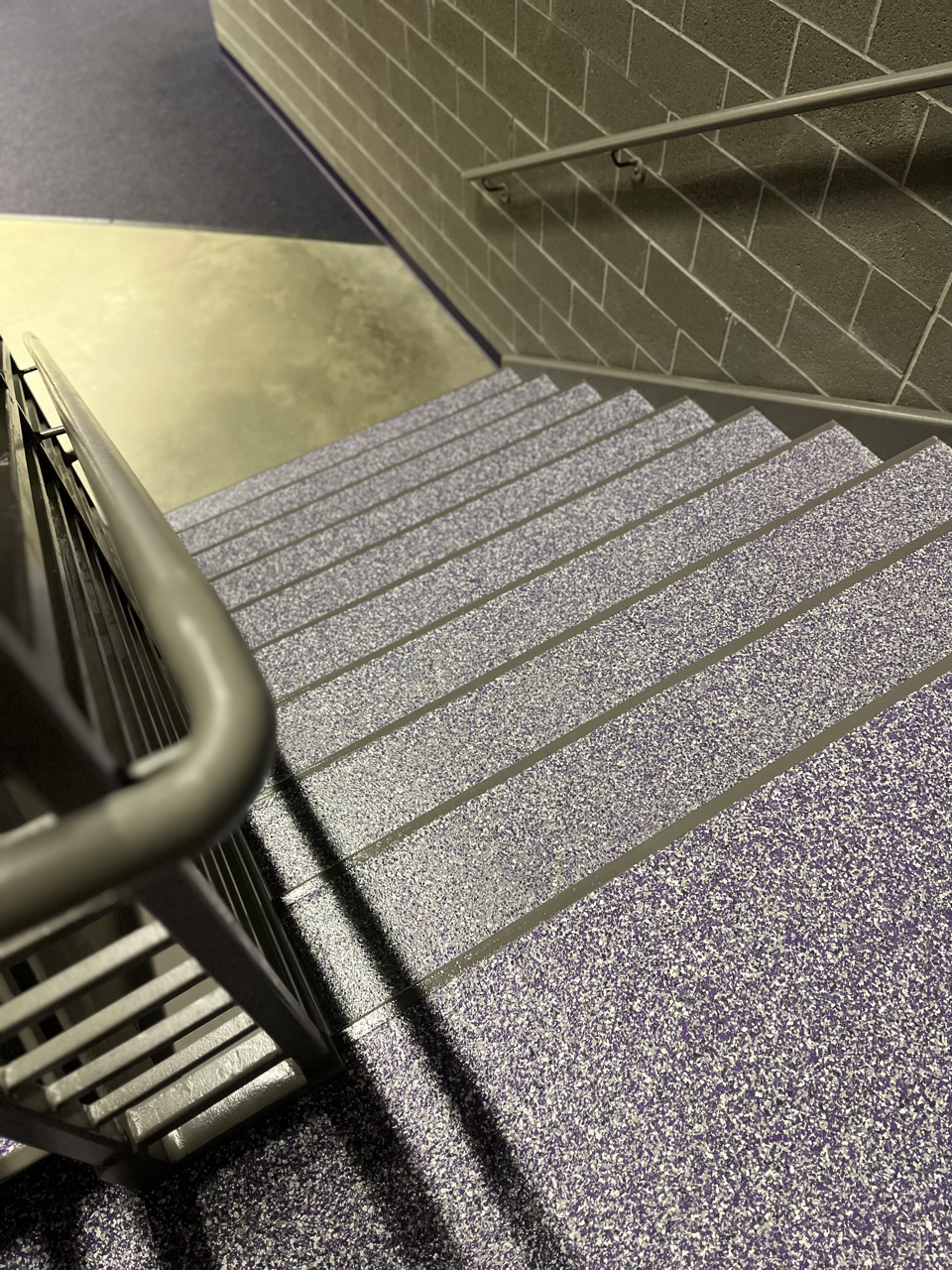 A staircase with purple steps and a brick wall