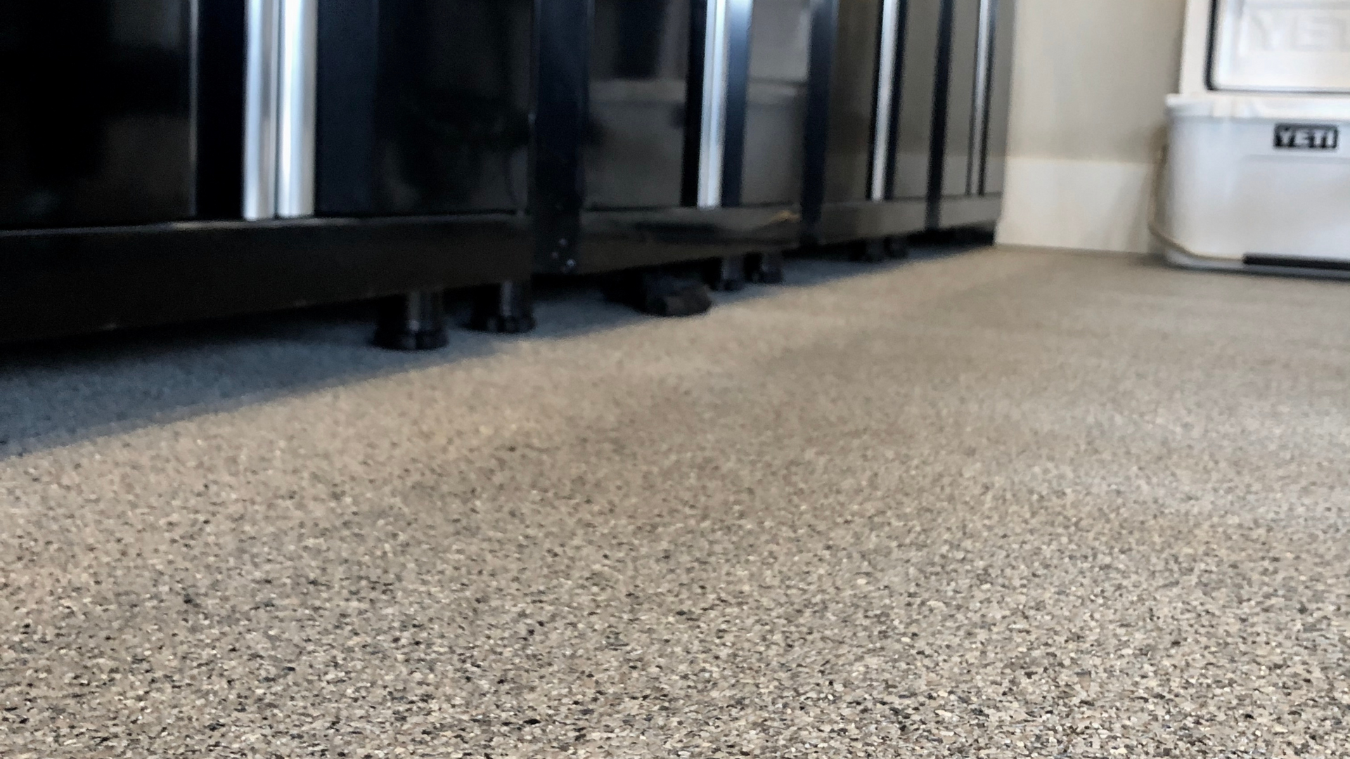 A close up of a carpeted floor in a room with black cabinets.