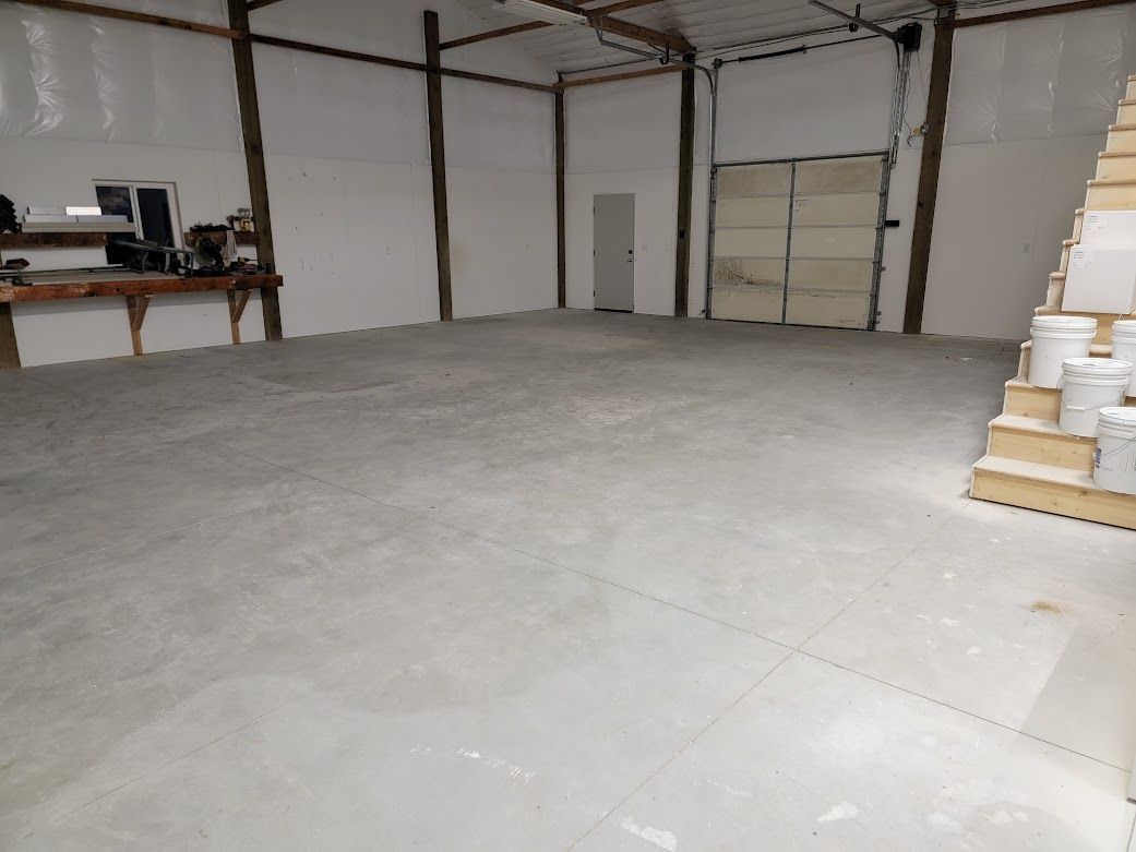 A large empty room with buckets on the floor