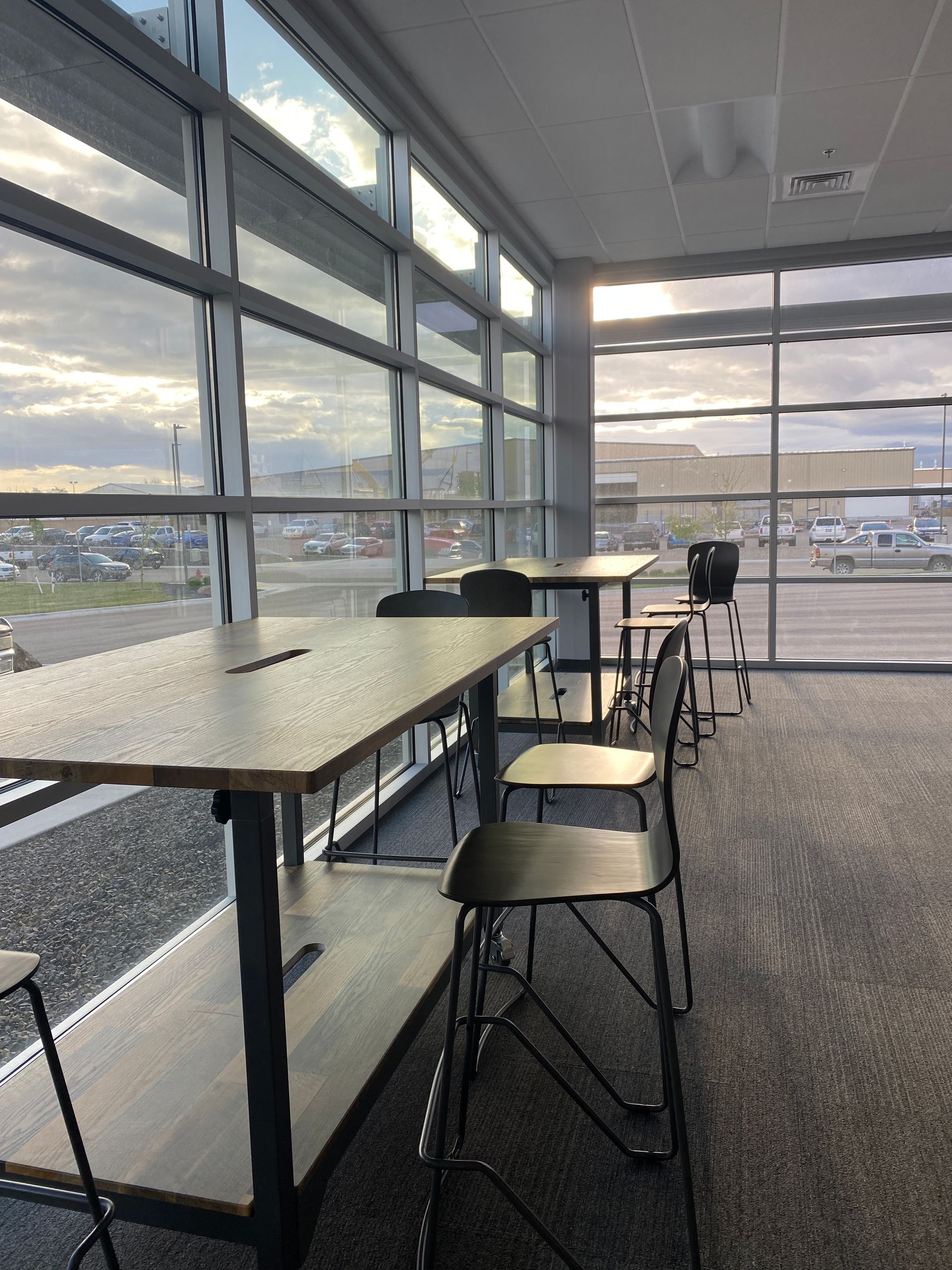 A room with a lot of windows and tables and chairs