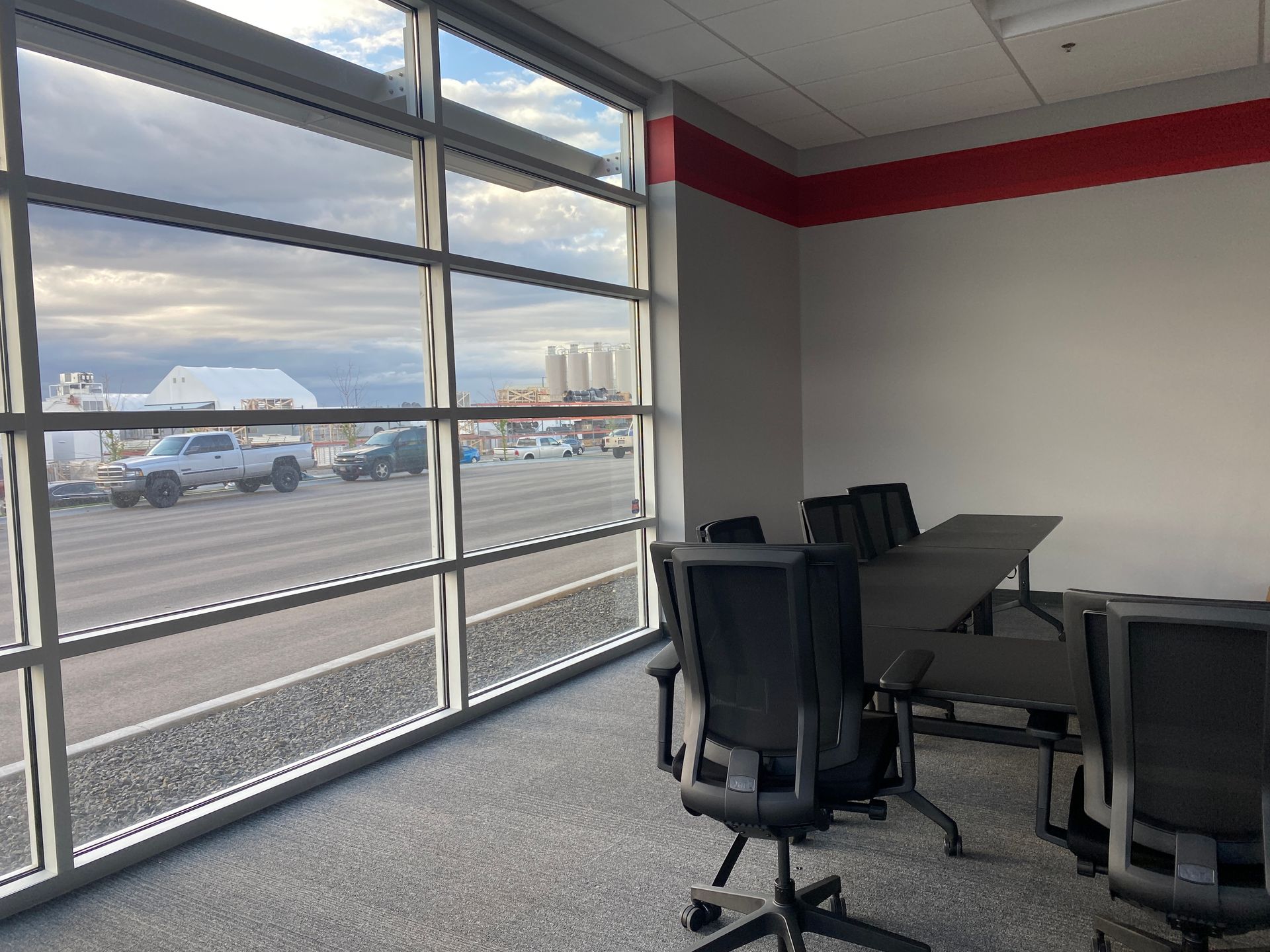 A conference room with a table and chairs and a large window.