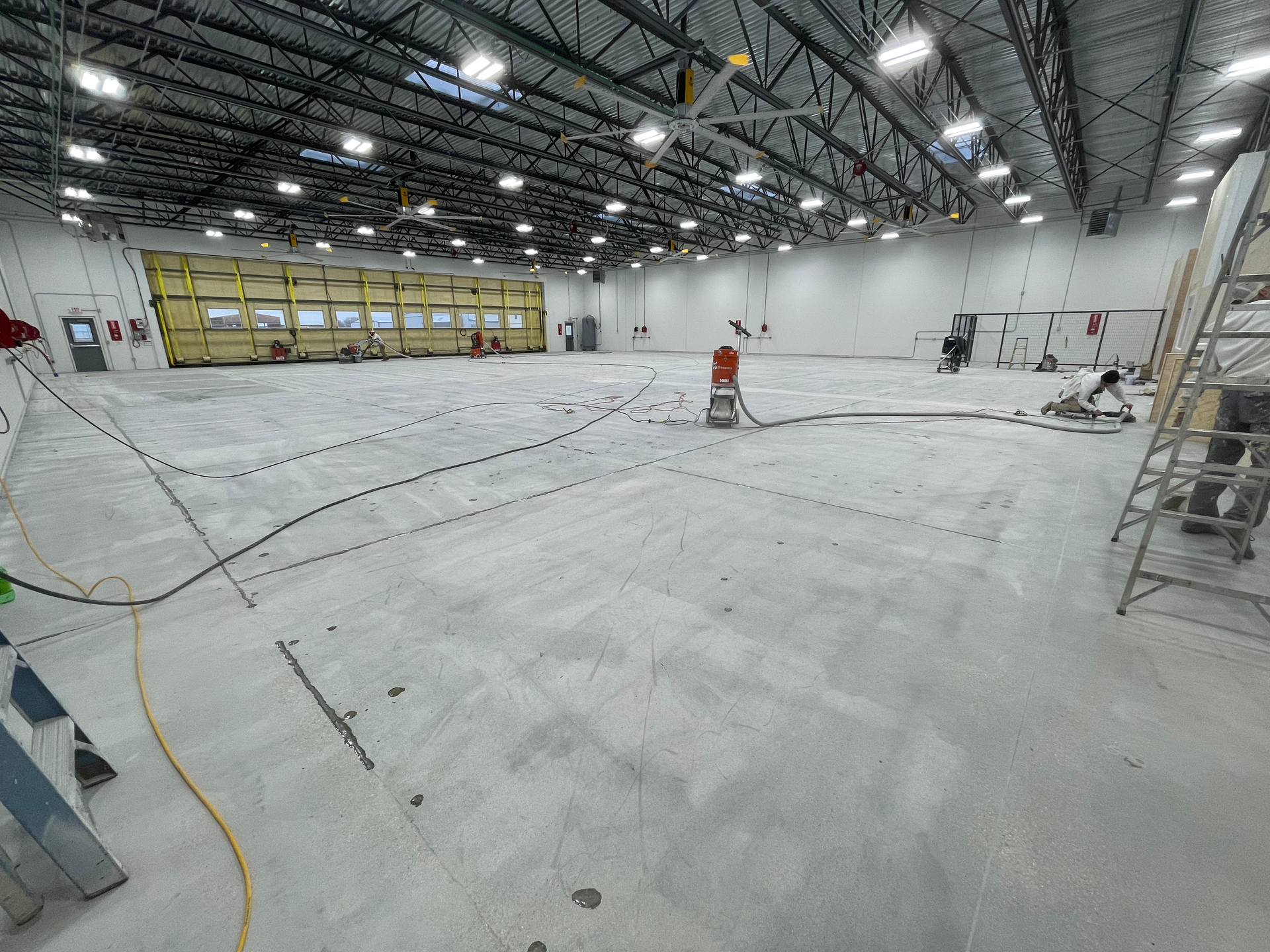 A large empty warehouse with a lot of lights on the ceiling.