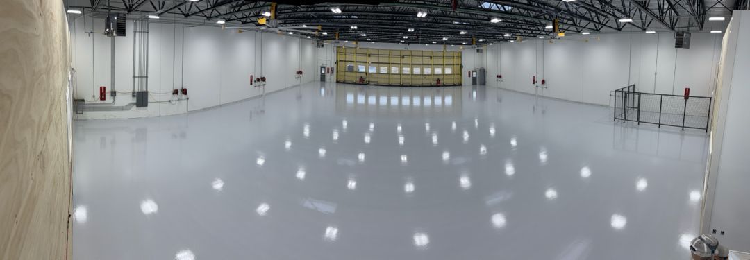A large empty warehouse with a lot of lights on the floor.