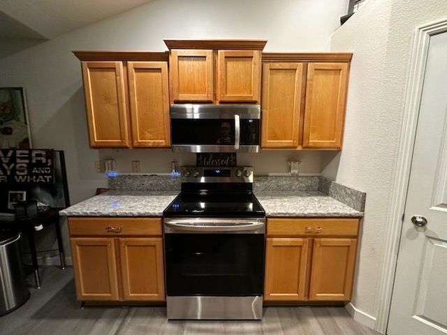 A kitchen with stainless steel appliances and wooden cabinets
