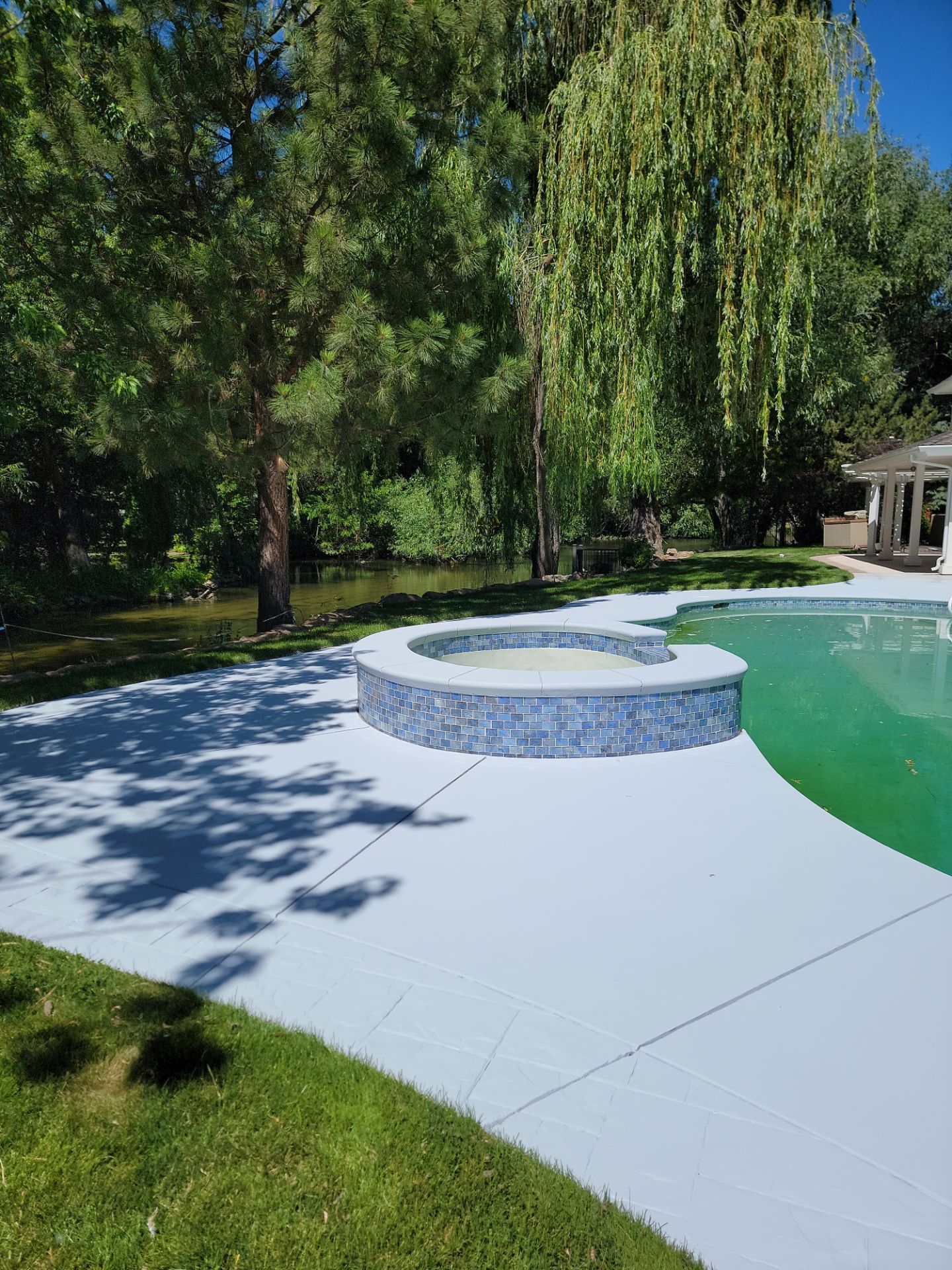 There is a swimming pool with a hot tub in the middle of it.