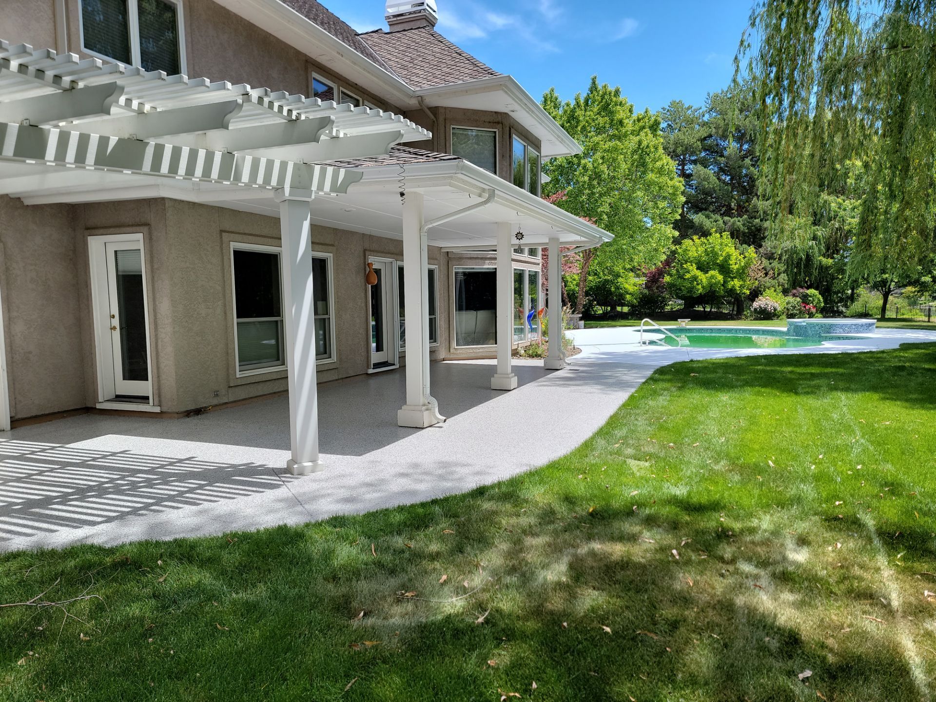 A large house with a pergola and a swimming pool in the backyard.