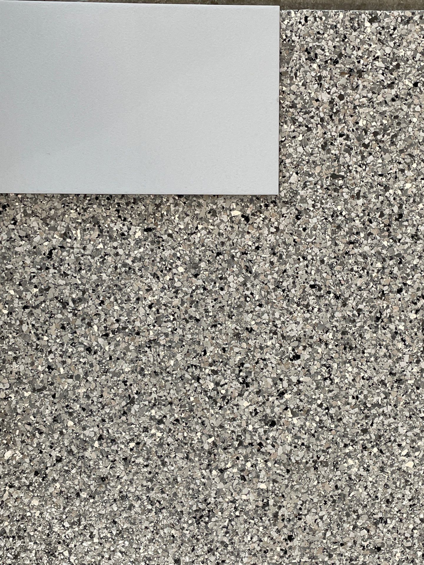 A close up of a gray granite counter top with a white border.