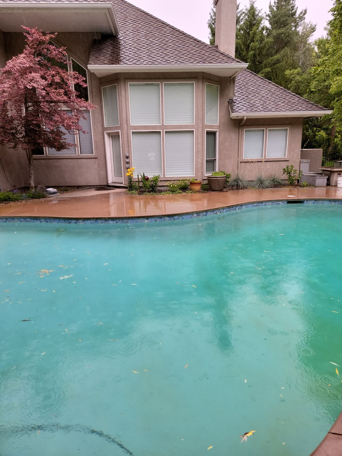 A large house with a swimming pool in front of it.
