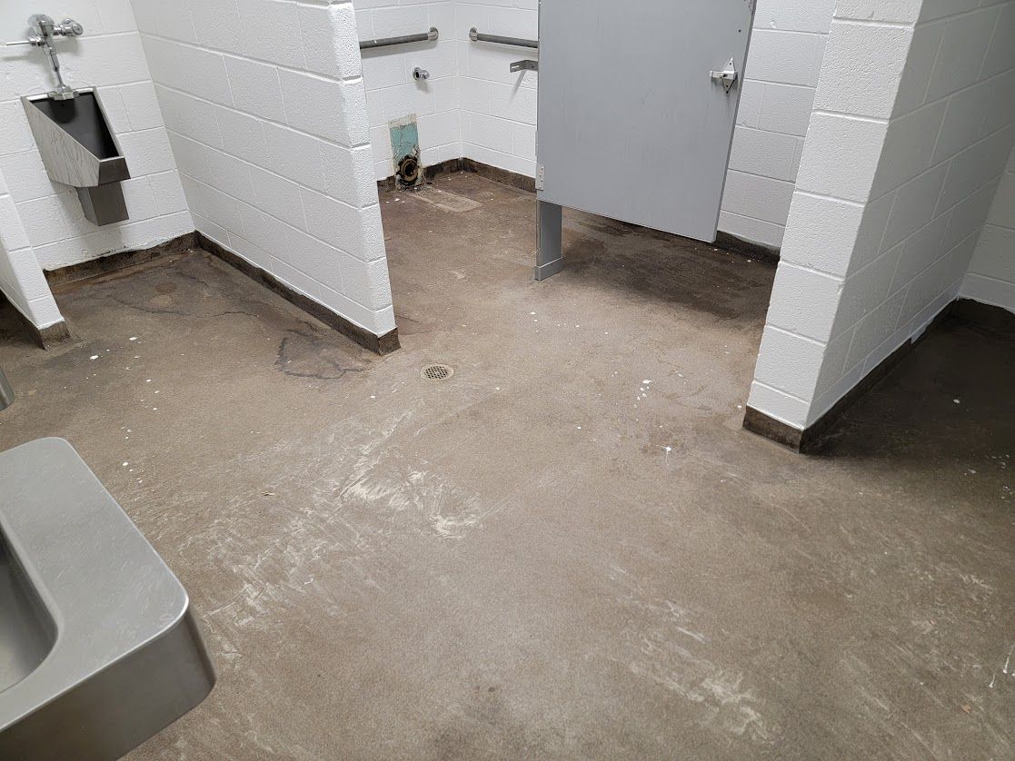 A bathroom with a sink , toilet and urinal.