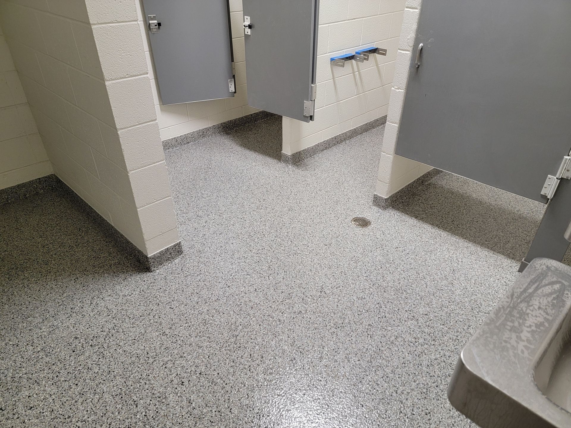 A bathroom with two stalls and a sink.