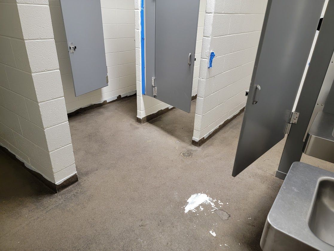 A bathroom with two stalls and a sink.