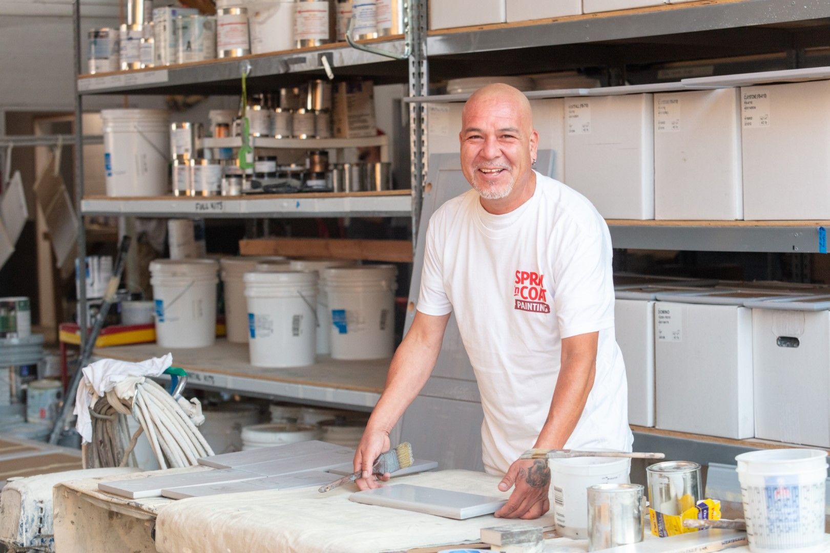 A man is standing in front of a table in a warehouse.