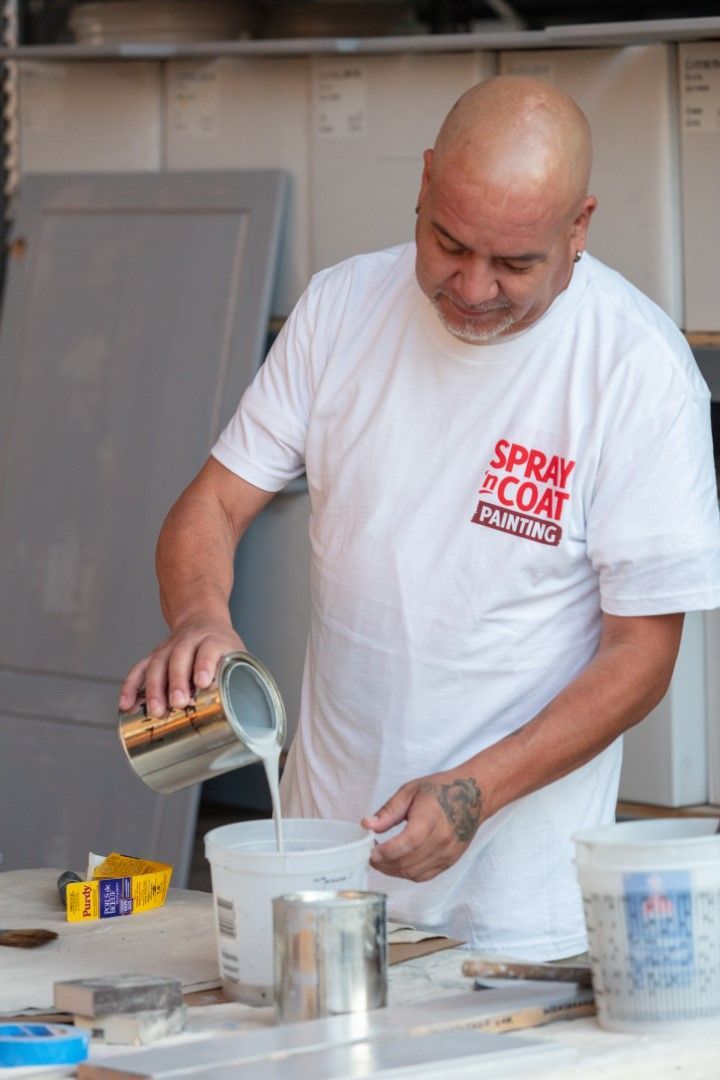 A man wearing a white shirt that says spray coat painting