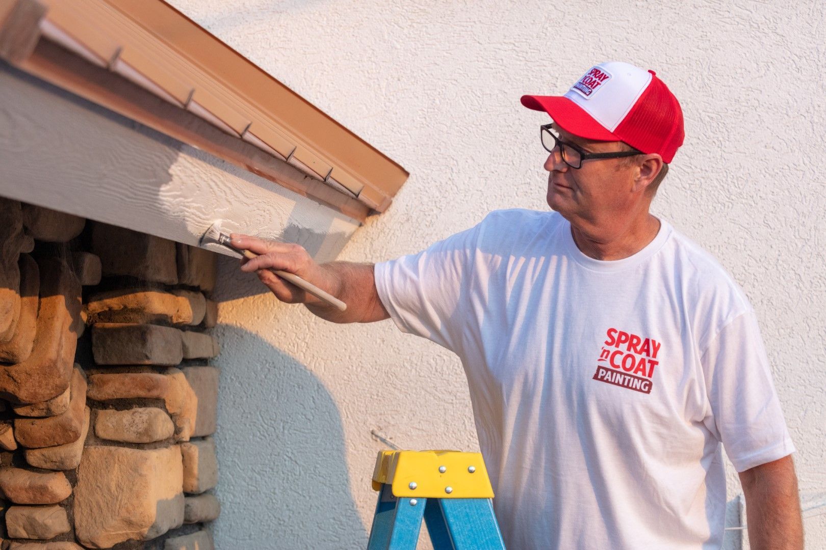 A man wearing a white shirt that says spray coat on it