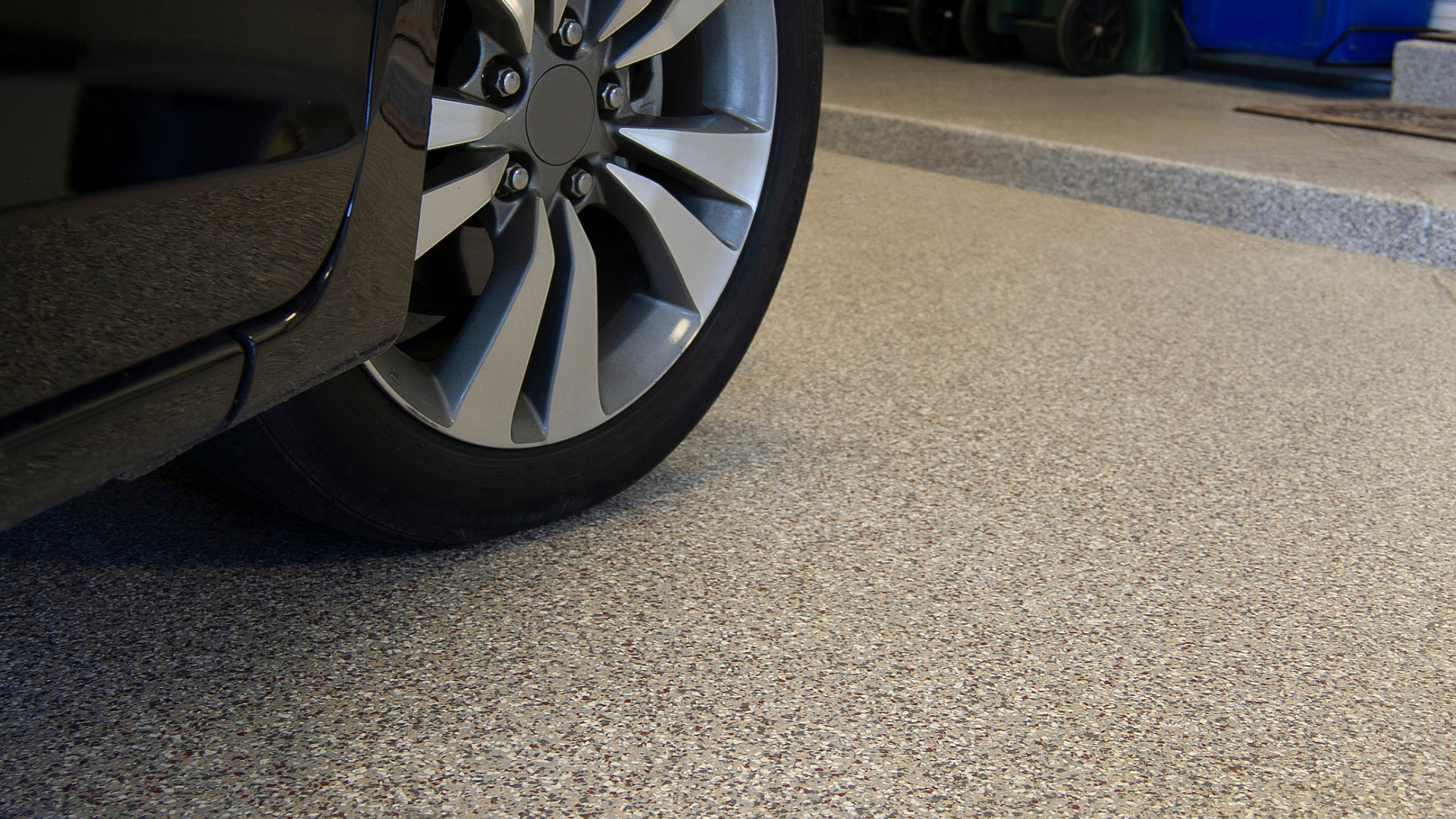 A car is parked in a garage with a concrete floor.