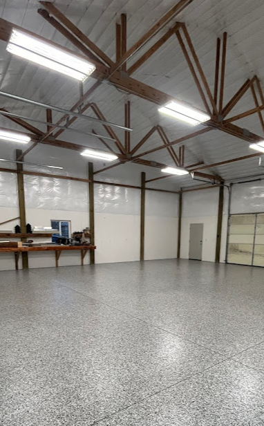 A large empty room with a gray floor and white walls.