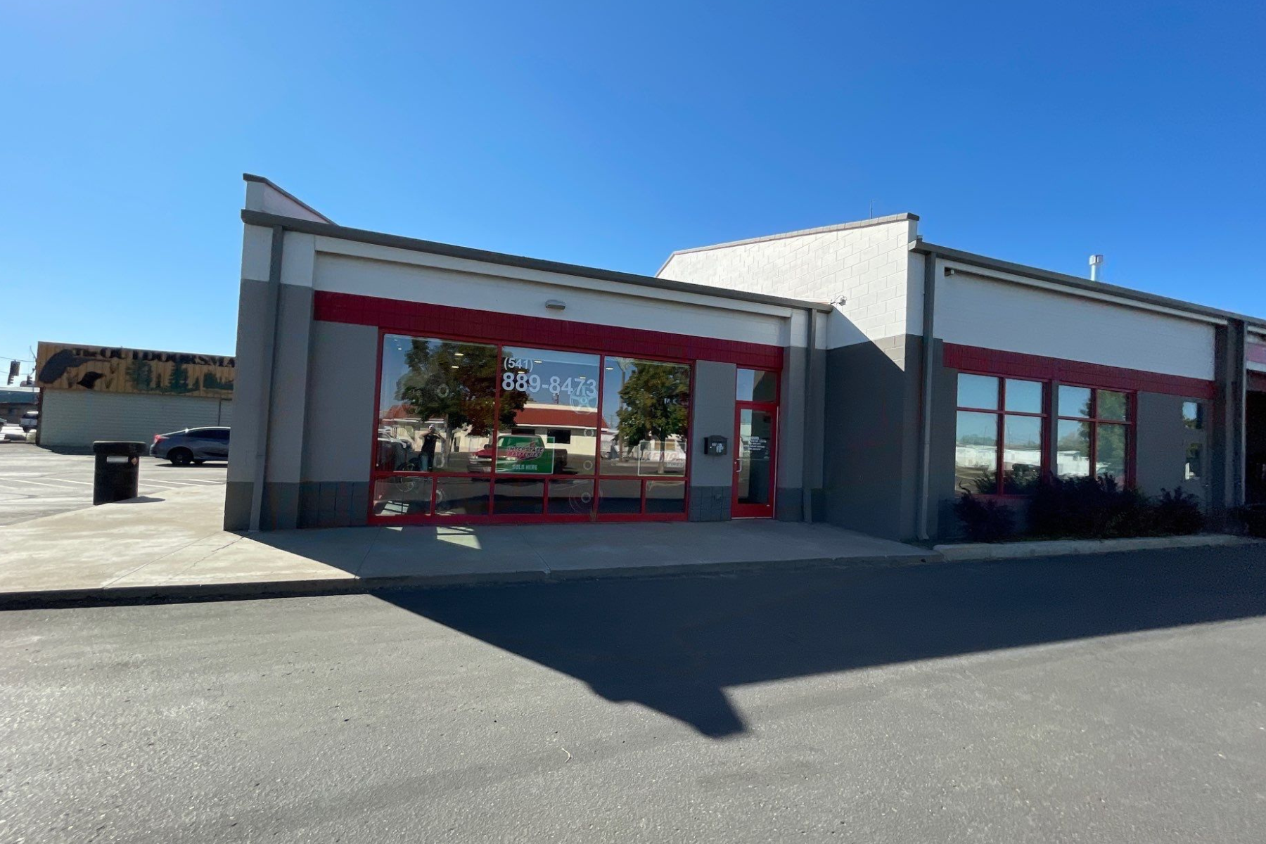 A large building with a lot of windows and a parking lot in front of it.