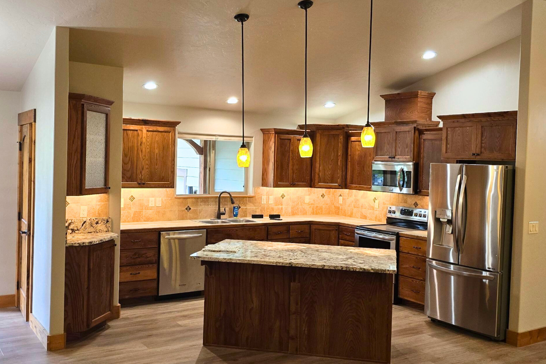 A kitchen with stainless steel appliances and wooden cabinets