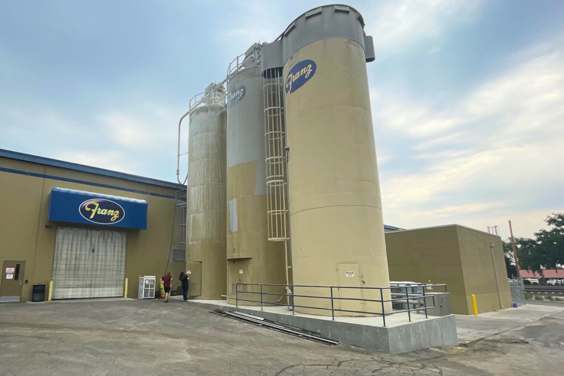 A large building with a lot of silos in front of it.