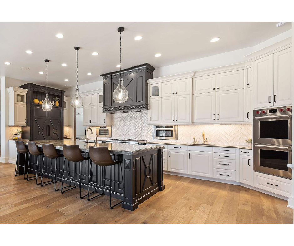 A large kitchen with white cabinets and stainless steel appliances and a large island.