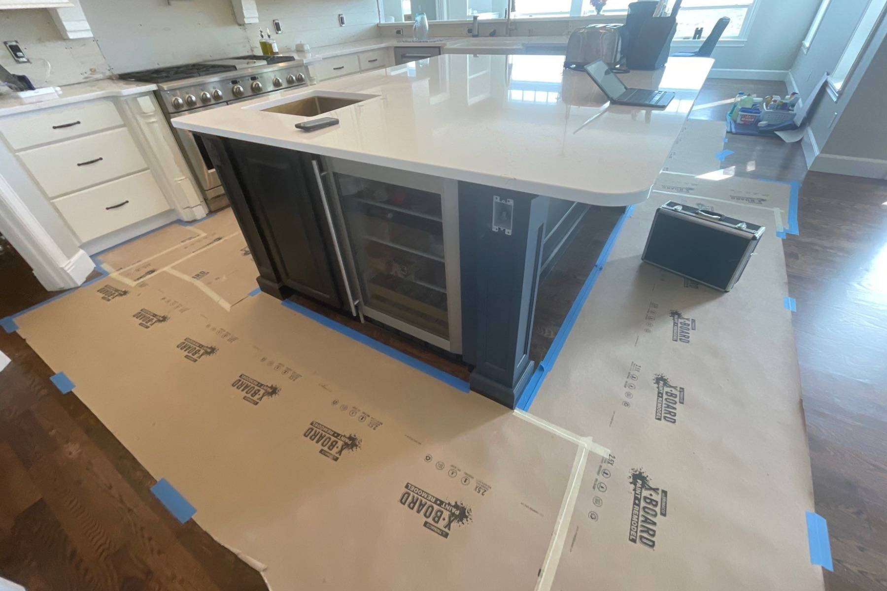 A kitchen with a large island in the middle is being painted.