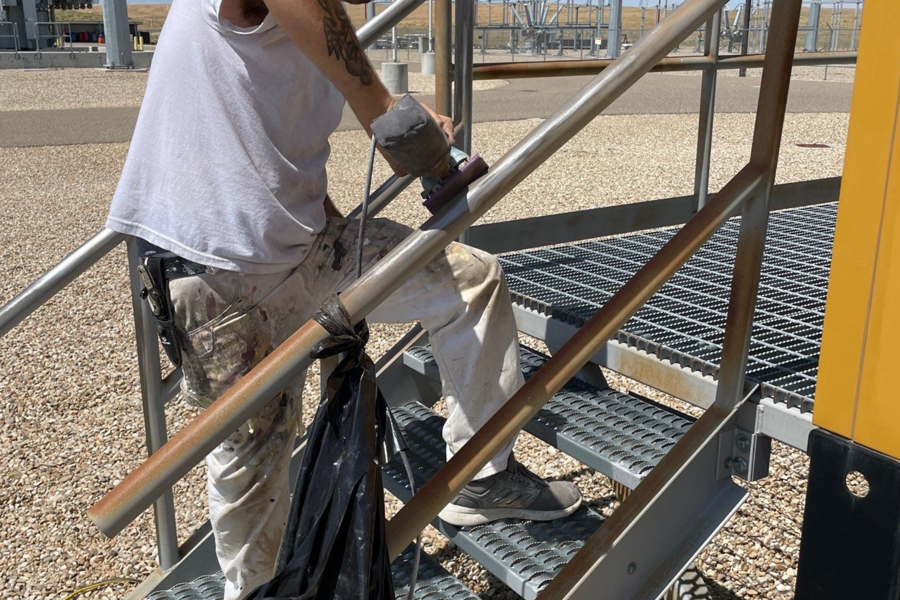 A man is sitting on a set of metal stairs