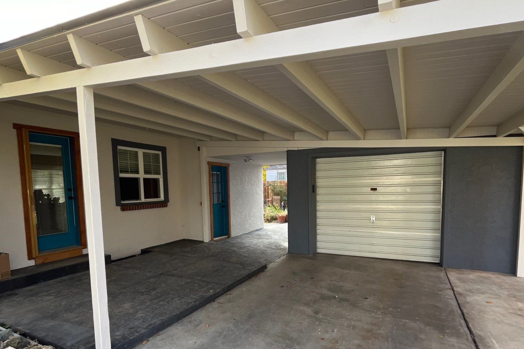 A white house with a blue door and a white garage door