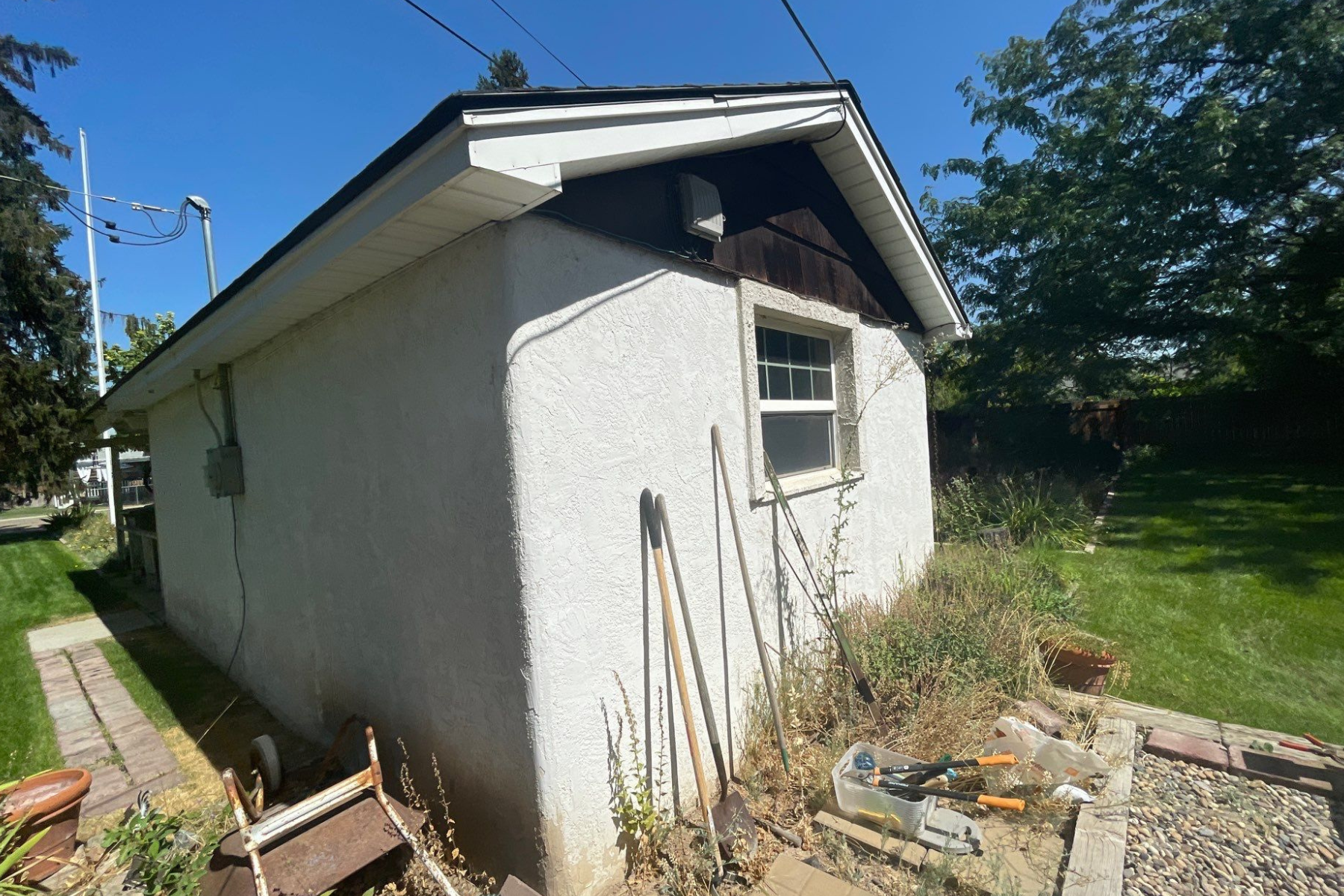 A small white house with a black roof and a window.