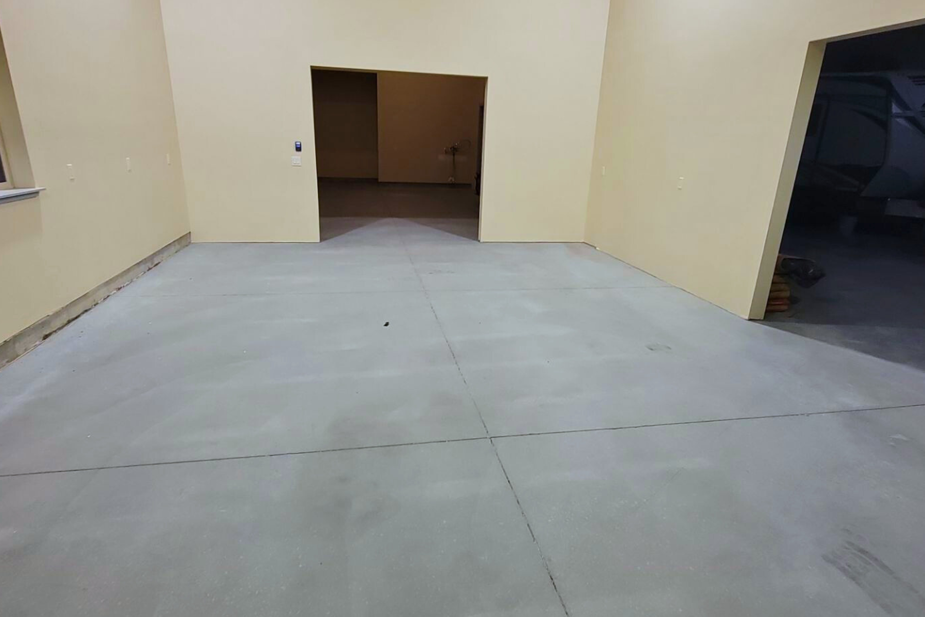 A large empty room with a concrete floor and walls.