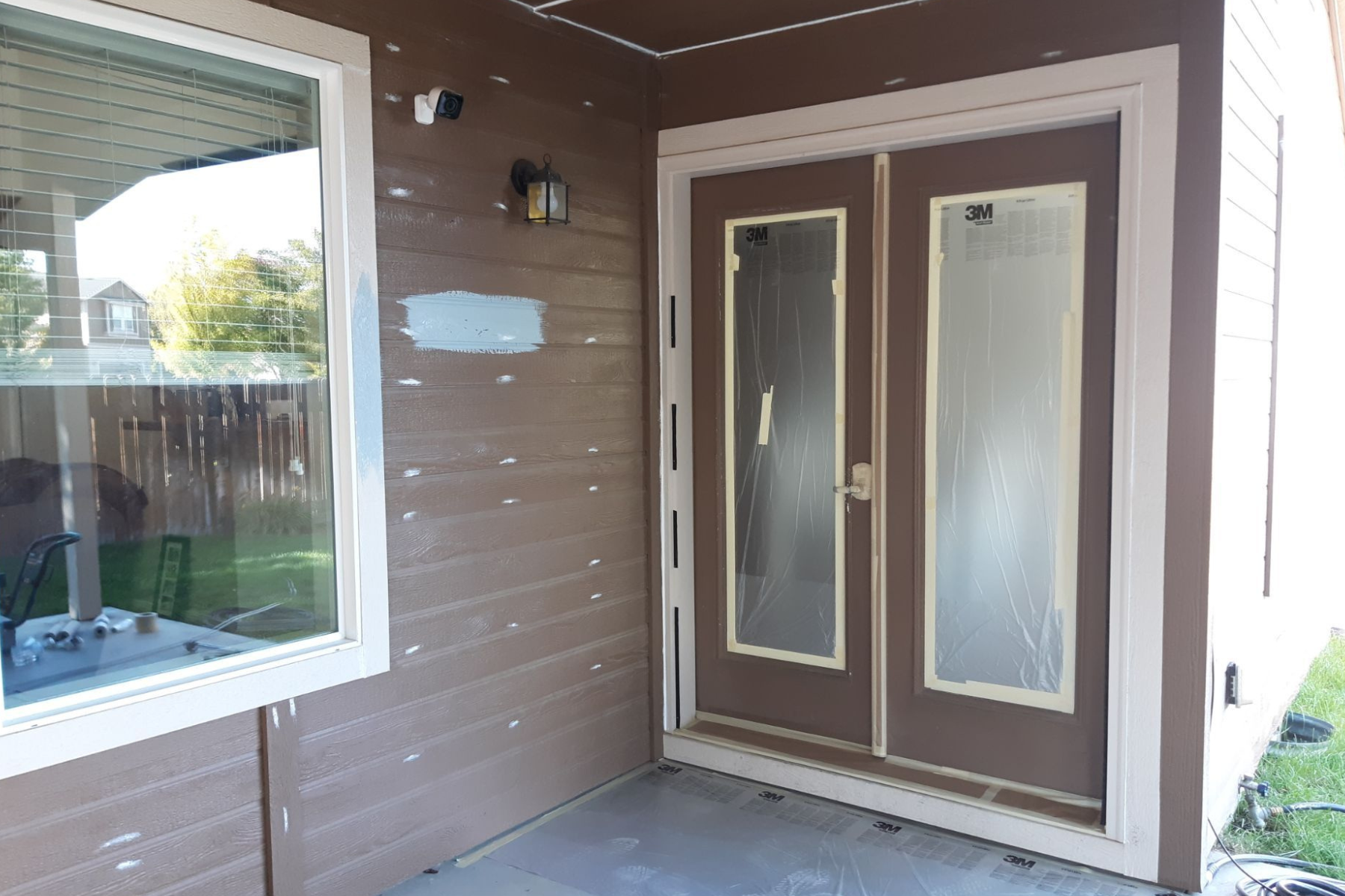 A brown house with a sliding glass door and a window.
