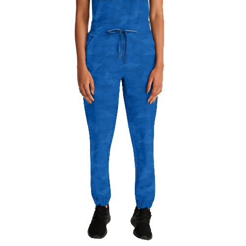 Woman in blue scrubs, drawstring pants, and black sneakers. White background.