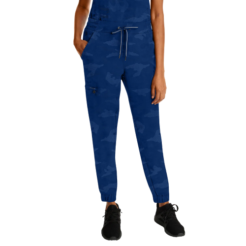 Woman wearing blue camouflage pants and black sneakers.