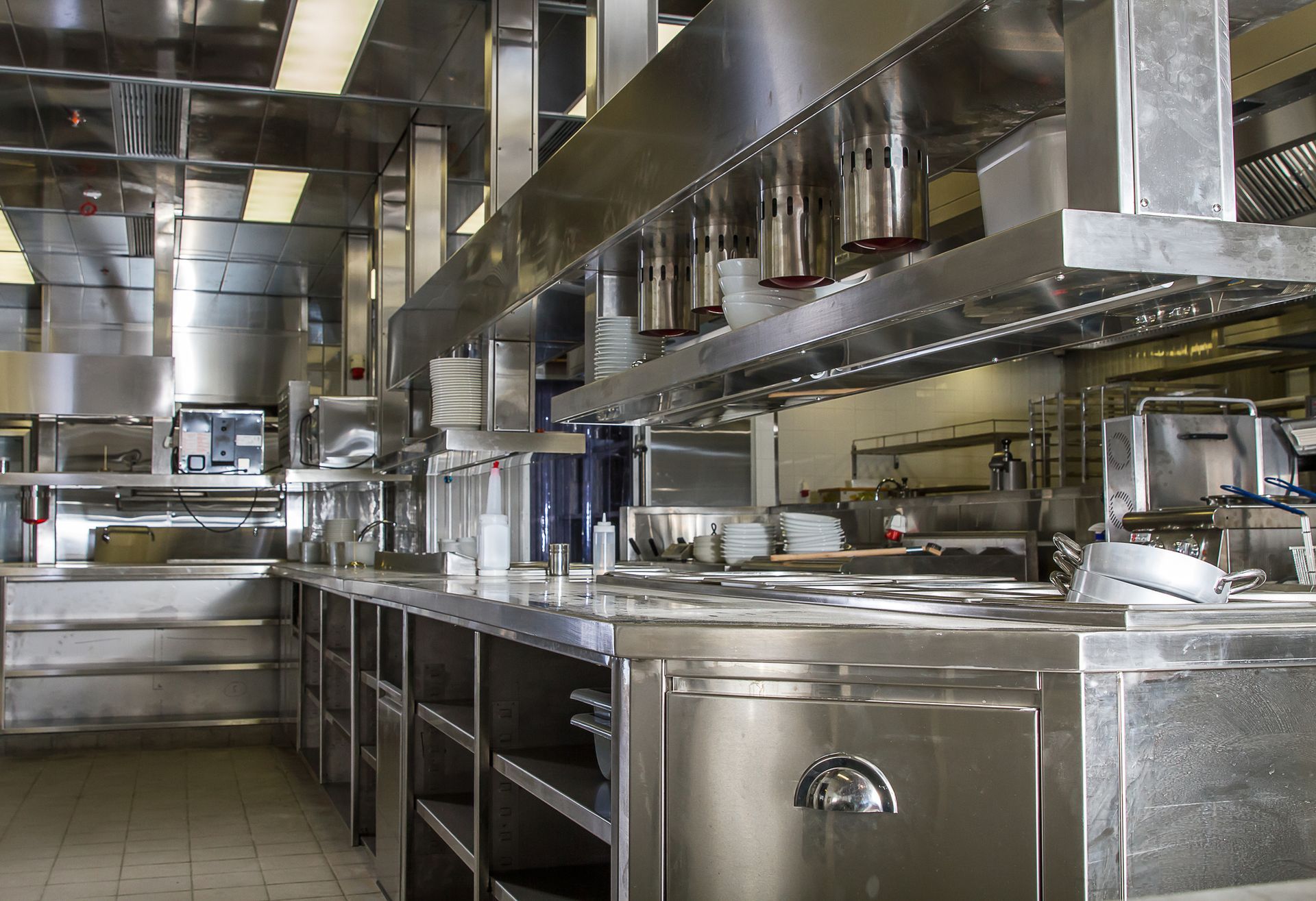 Modern commercial kitchen showing steel counter, showcasing commercial kitchen exhaust cleaning.