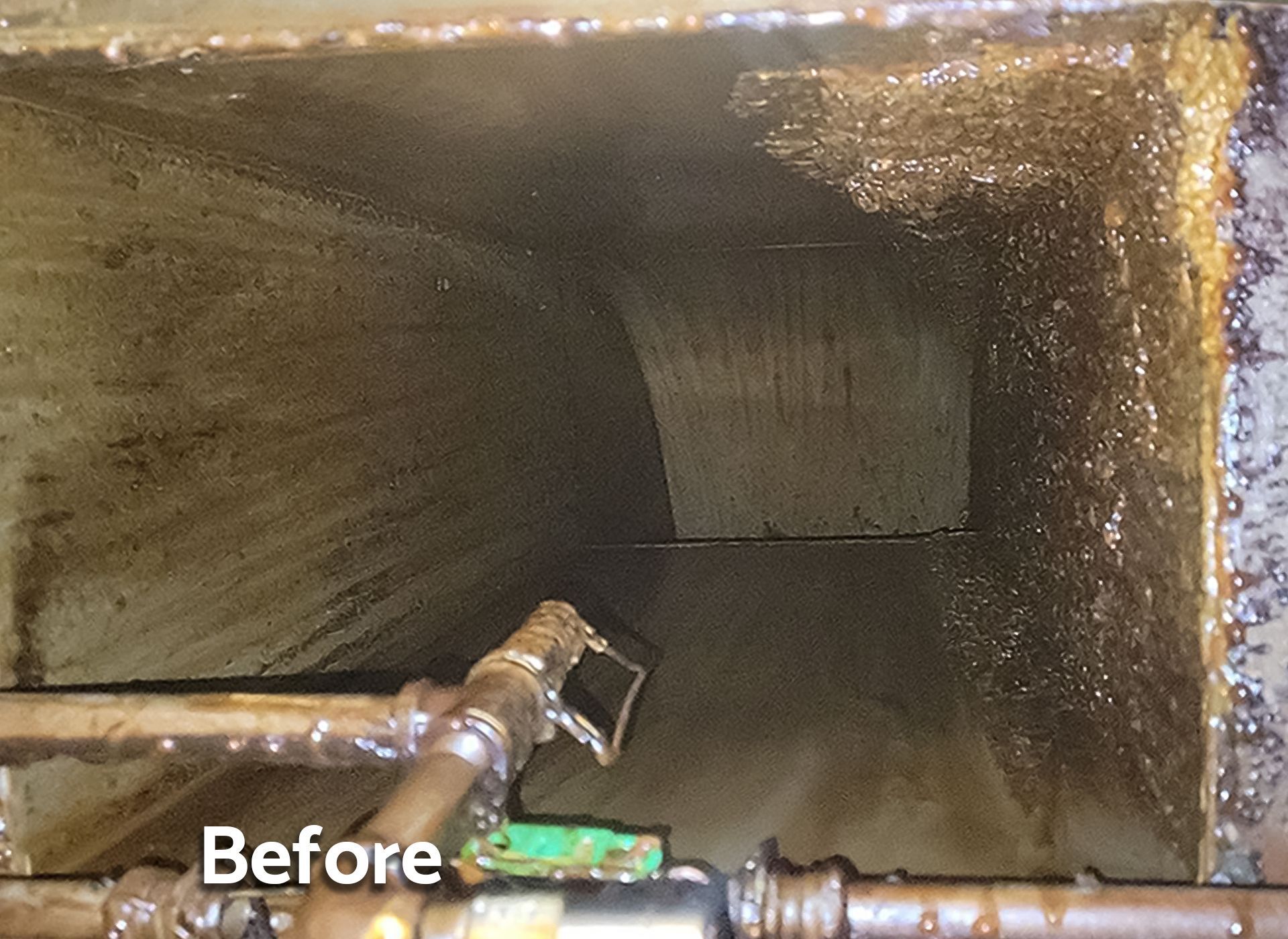 A before picture of a dirty room with pipes