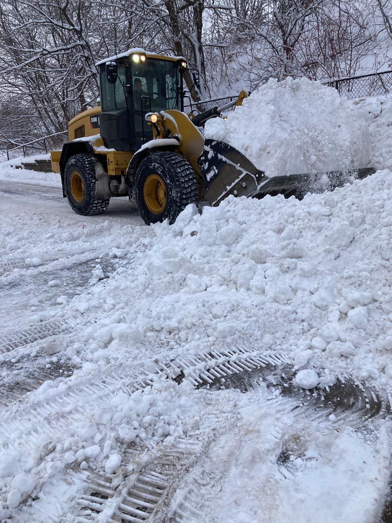 A bulldozer is clearing snow from a road.