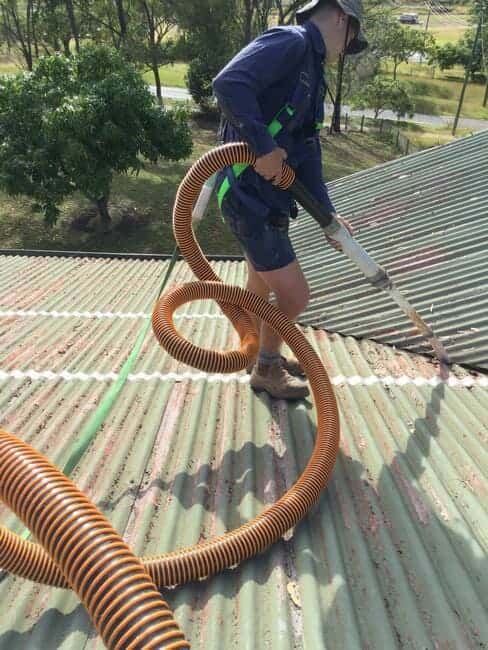 Plumber cleaning gutters on roof - Gutter Cleaning Gladstone, QLD