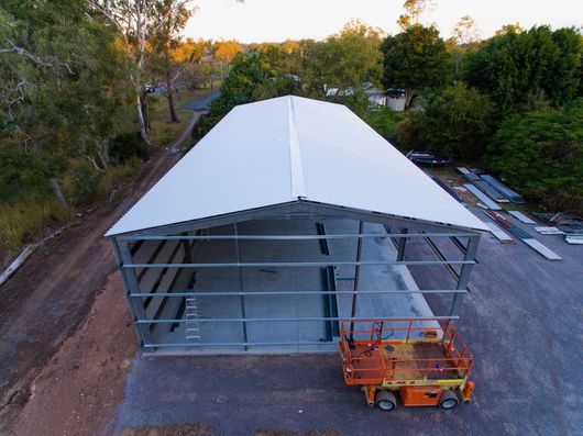 outdoor installation of new steel roof with guttering in gladstone