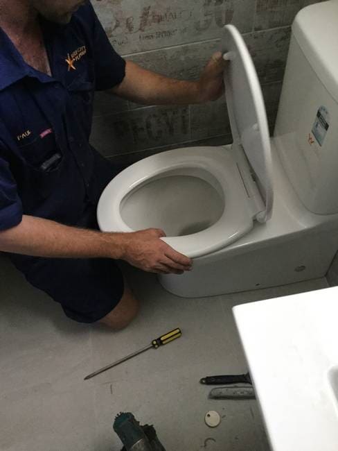 Plumber installing new toilet bowl in Gladstone - Plumbing Gladstone